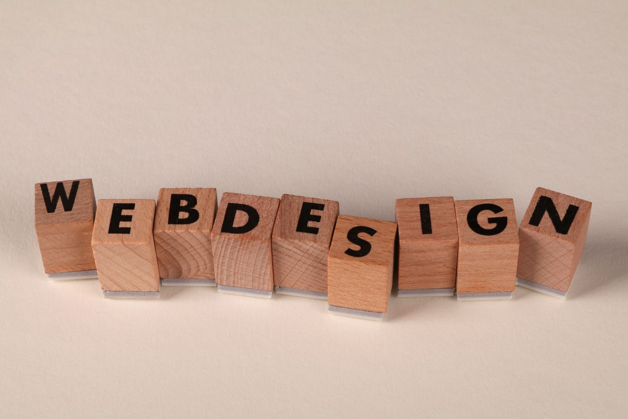 Des blocs de bois formant web design illustrent de façon créative le concept du design numérique.